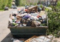 Overfilled dumpster in ghetto, trash needs recycling. Environment pollution