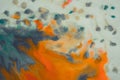 Overflowing bright orange and dark blue paint on paper