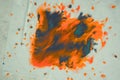 Overflowing bright orange and dark blue paint on paper