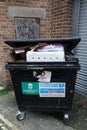 Overflowing commercial waste bin rear of shops