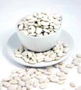 Overflowing cup of dry white beans on textured background Royalty Free Stock Photo