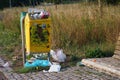 An overflowing garbage can in a park