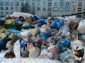Overflowing garbage containers in a yard of an apartment house
