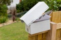 Overflowing letterbox on fence post