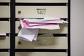 An overflowing mailbox in the lobby of an apartment building. Mailboxe Royalty Free Stock Photo