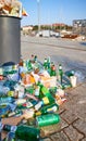 An overflowing trash can on the pavement of Lasztownia Island boulevard at sunrise