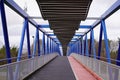 Overground Pedestrian blue Metal Crossing bridge walkway red black path Modern building perspective Royalty Free Stock Photo