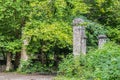 Overgrown abandoned ruins in the forest - Old road running between pillars from Soviet-era resort in the Republic of Georgia in Royalty Free Stock Photo