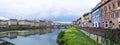 Overgrown Arno river waterfront with Ponte Santa Trinita StTrinity bridge in Florence, Italy Royalty Free Stock Photo