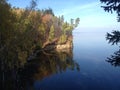 Overgrown cliff shore juts out into the depths of the lake