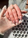 Overgrown gel polish on the hand on the background of a vacuum cleaner.