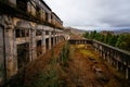 Overgrown ruins of industrial building. Abandoned, destroyed by war power plant in Tkvarcheli Tquarhcal, Abkhazia, Georgia Royalty Free Stock Photo