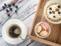 Overhaed view of breakfest included cup of coffee and bowls in wooden box with oatmeal and cakes