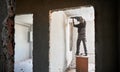 Overhaul of premise. Worker dismantling wall with jackhammer. Royalty Free Stock Photo