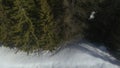 Overhead aerial drone flight establisher over snowy sunny forest woods. Winter snow in mountain nature outdoors