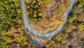 Overhead aerial top view over hairpin turn road bend in colorful countryside autumn forest.Fall orange,green,yellow,red