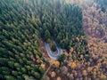 Overhead aerial top view over hairpin turn road bend in countryside autumn pine forest.Fall orange,green,yellow,red tree Royalty Free Stock Photo