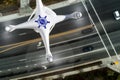 Overhead Aerial view of a Police Drone Flying Over a Traffic Intersection Crosswalk