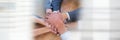 Overhead of business team putting hands together on table and white blurry framing Royalty Free Stock Photo