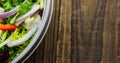 Overhead close-up of fresh vegetables salad in glass bowl on wooden table, copy space Royalty Free Stock Photo