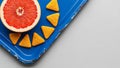 Grapefruit Half and Triangular Crackers on Distressed Blue Tray Royalty Free Stock Photo