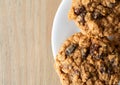 Top close view of homemade oatmeal raisin cookies on a white plate atop a table illuminated with natural light Royalty Free Stock Photo