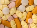 Overhead closeup shot of yellow orange pink and white pills Royalty Free Stock Photo