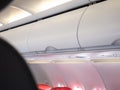 Overhead compartment in aircraft cabin. white storage bin door for advertising placement.