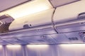 Overhead compartment - detail of an airplane cabin interior toned in violet and yellow