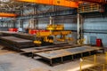 Overhead crane with electromagnetic beam grippers lifting steel sheets