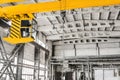Overhead crane hoist equipment in an industrial plant transports an iron rail on lifting chain