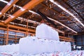 Overhead crane lift jumbo bags of tapioca using spread bar in storage warehouse. Bulk cargo in jumbo bag handling equipmet.