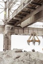 Overhead crane with mechanical multivalve clamshell grab in outdoors industrial plant shop