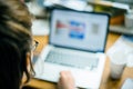 Overhead defocused view of woman looking at the open laptop running work