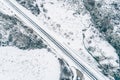 overhead drone aerial view of a road in a snowy landscape, winter time transportation concept Royalty Free Stock Photo