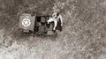 Overhead, drone, looking down on Male army officer in uniform resting on back of military vehicle Royalty Free Stock Photo
