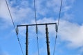 Overhead electrical power lines on old wooden pillars against the blue sky Royalty Free Stock Photo