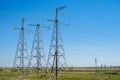 Overhead electricity transmission lines in the summer, against the background of the blue sky. . Royalty Free Stock Photo