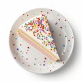 Overhead view of a slice of birthday celebration cake isolated against a plain white background