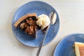 Overhead flatlay view of a slice of chocolate pecan pie with vanilla ice cream and a spoon on a blue plate Royalty Free Stock Photo