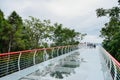 Overhead glass paved walkway on hill in cloudy summer