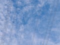 Overhead high voltage electricity transmission cables - part of the UK national grid - against a blue sky with white clouds Royalty Free Stock Photo