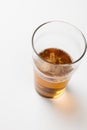 Overhead image of half full pint glass of lager beer, with copy space on white background Royalty Free Stock Photo