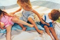 Overhead image of happy children sitting on the blanket, playing together. Cute little girls and little boy laughing and having