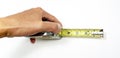 Overhead object shot of a hand holding a tape measure isolated on a white background.