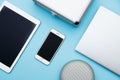 Overhead of office table with laptop, tablet pc, cellphone, speaker and bag. copy space blue flat lay Royalty Free Stock Photo