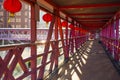 Overhead pedestrian walking bridge with traditional chinese red lamps leads to nearby facilities