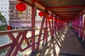 Overhead pedestrian walking bridge with traditional chinese red lamps leads to nearby facilities