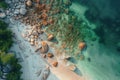 An overhead perspective captures a beach adorned with rocks and lapped by gentle waves, Bird-eye view of a sandy shore strewn with