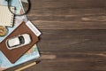 Overhead photo of brown passport with covid-19 test inside car map magnifier compass notepad and pen isolated on the wooden